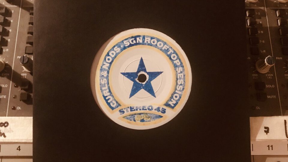 Rundes Emblem mit blauem Stern auf einem schwarzen Bedienfeld zwischen Reglern
